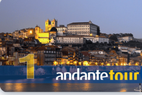 Sunset view of historic city waterfront with illuminated buildings and “1 andante tour” text overlay.
